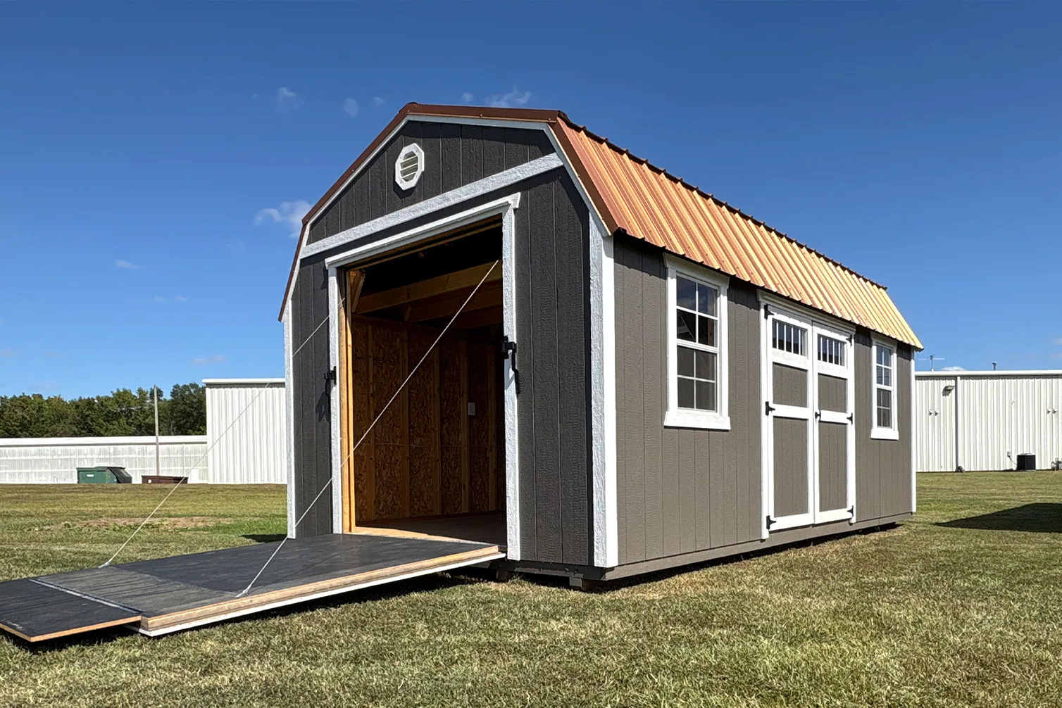 Lofted barn shed with a ramp and metal roof
