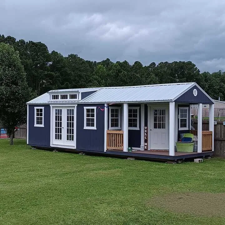 Blue tiny home with a full porch