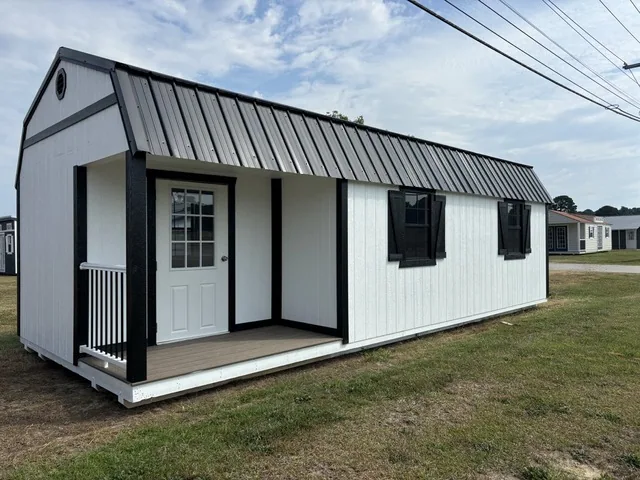 White tiny home with a corner porch